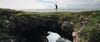 May walking over a natural rock bridge in Westport, County Mayo